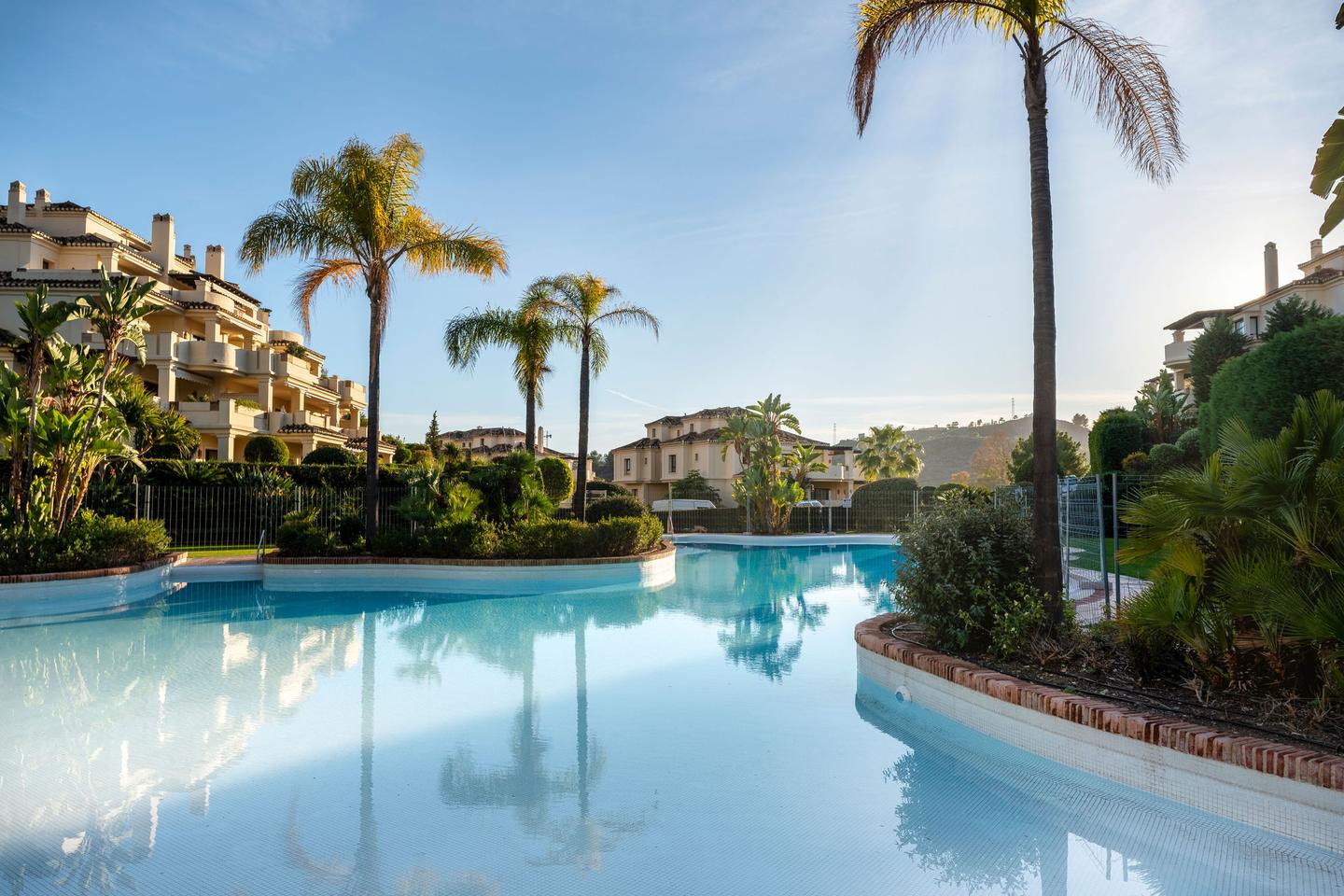 Piscina del complejo con palmeras, Apartamento en Capanes del Golf